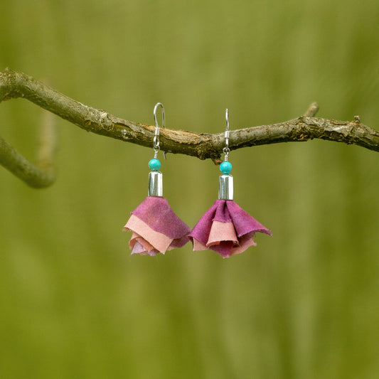 Short silver earrings with pink flowers and real turquoise accent, hanging from a branch